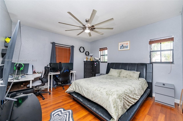 bedroom with wood finished floors, baseboards, and ceiling fan