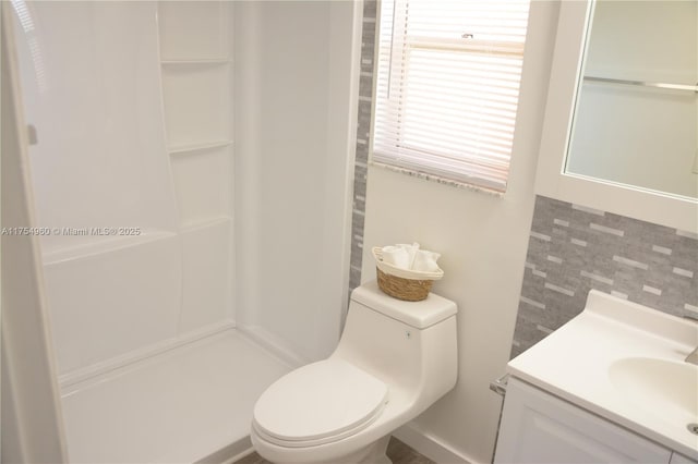 bathroom featuring tasteful backsplash, a shower, toilet, and vanity