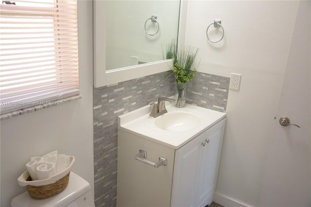 half bathroom featuring vanity and tasteful backsplash