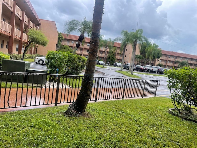 surrounding community featuring a lawn and fence