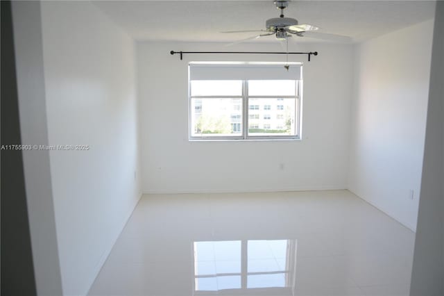 unfurnished room featuring baseboards and ceiling fan