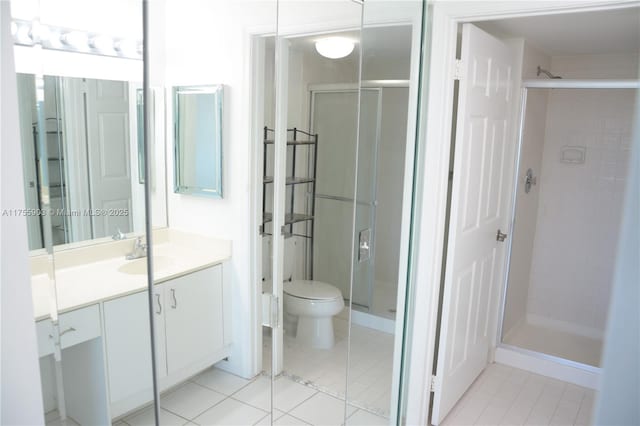 full bathroom featuring vanity, toilet, a shower stall, and tile patterned flooring