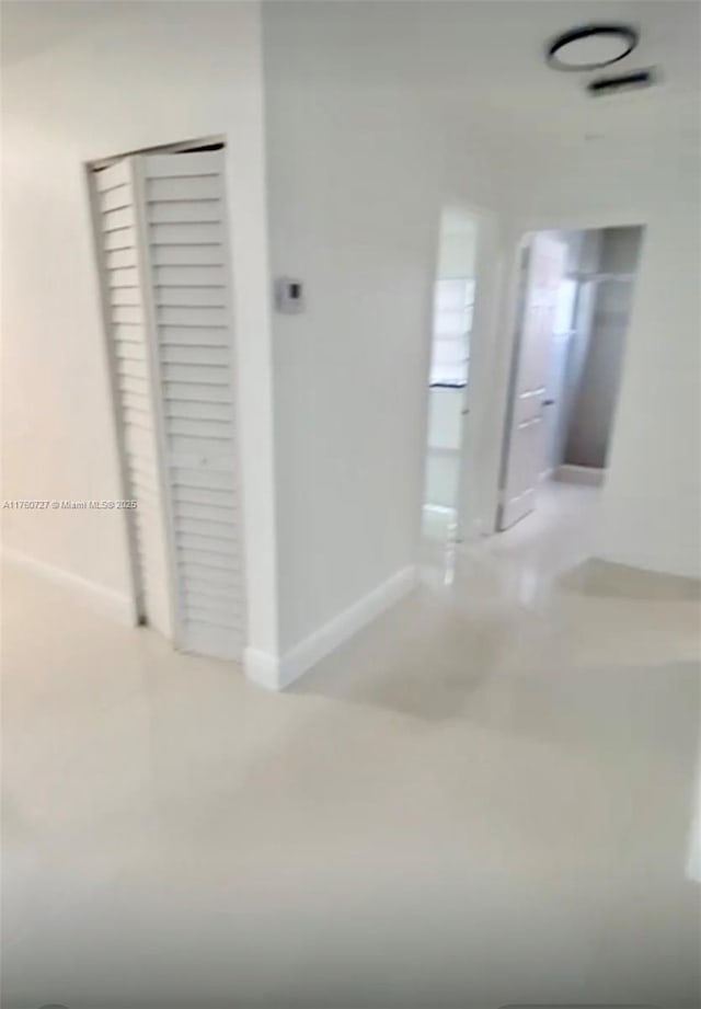 hallway with visible vents and baseboards