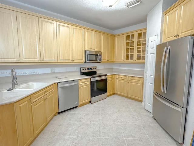 5737 NW 119th Dr Unit 5737, Coral Springs, FL 33076 - kitchen with light brown cabinets, visible vents, a sink, light countertops, and appliances with stainless steel finishes