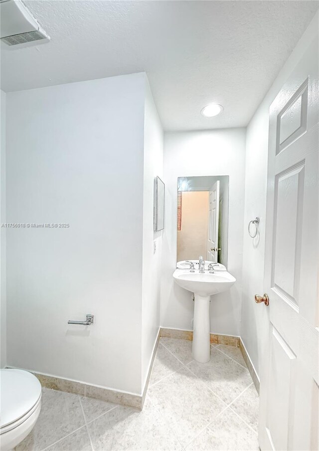 5737 NW 119th Dr Unit 5737, Coral Springs, FL 33076 - half bath with toilet, baseboards, visible vents, and a textured ceiling