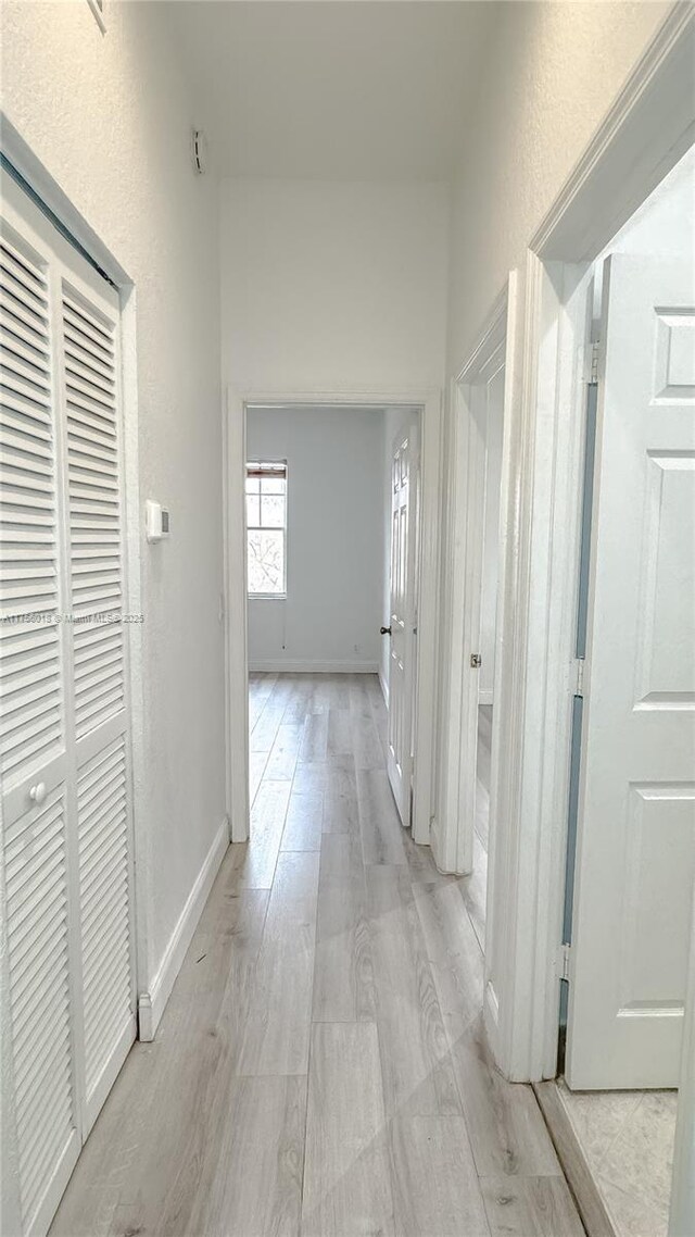 5737 NW 119th Dr Unit 5737, Coral Springs, FL 33076 - hallway with light wood finished floors, baseboards, and a textured wall