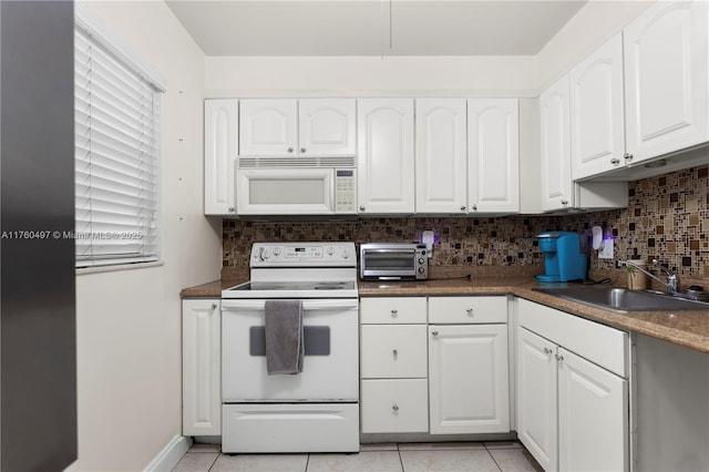 kitchen with backsplash, a toaster, light tile patterned flooring, white appliances, and a sink