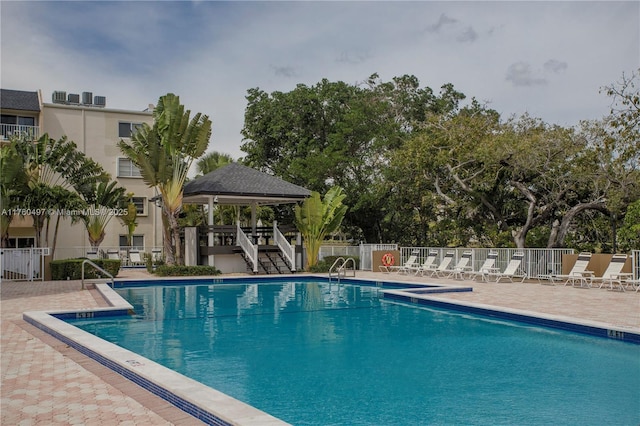 pool with a gazebo, a patio, and fence