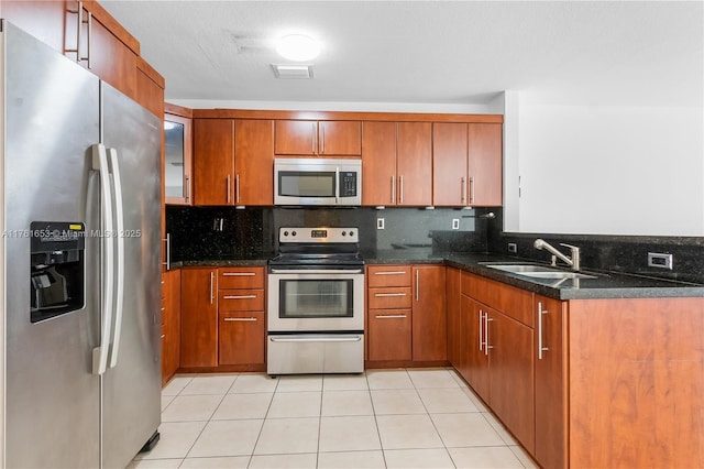 kitchen featuring brown cabinets, visible vents, appliances with stainless steel finishes, and a sink