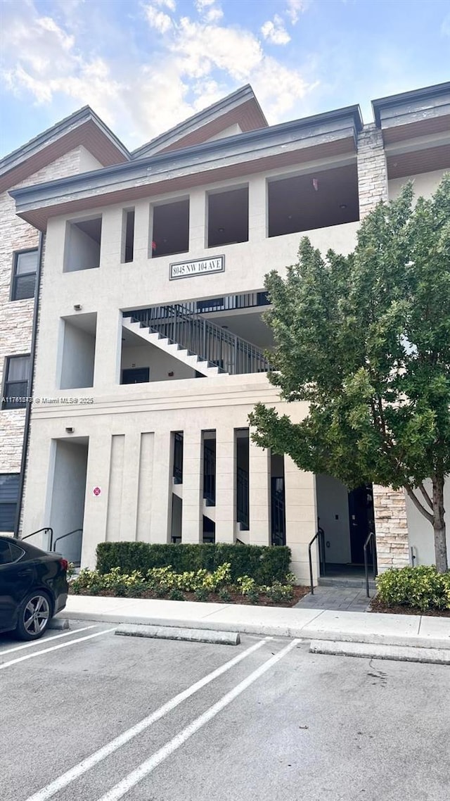 view of building exterior with uncovered parking