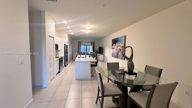 dining space featuring light tile patterned floors and baseboards