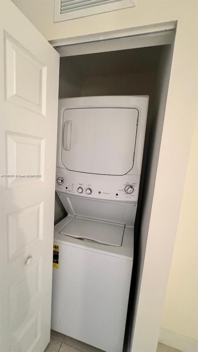 laundry room with laundry area and stacked washer / dryer