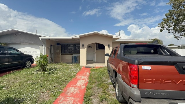 ranch-style home with central air condition unit, stucco siding, and a garage