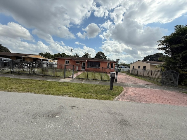 manufactured / mobile home featuring a front lawn, a gate, and a fenced front yard