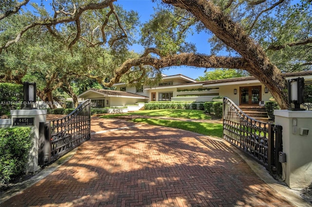 view of front of home with a gate, french doors, a fenced front yard, and stucco siding