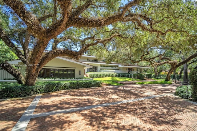 view of front of property with a front lawn, decorative driveway, and stucco siding