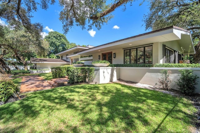 view of front of property with stucco siding and a front yard