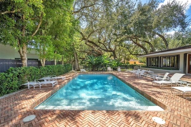 community pool featuring a fenced backyard and a patio area