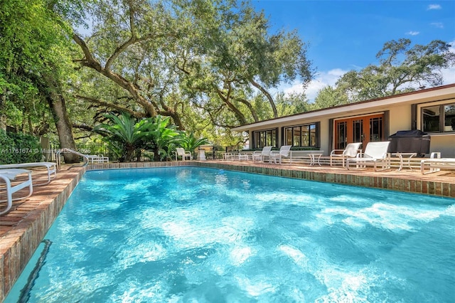 pool featuring french doors, a patio, and fence