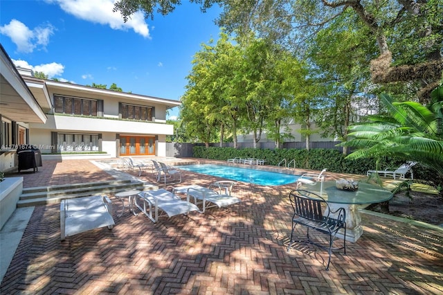 view of swimming pool with a fenced in pool, a patio, and fence