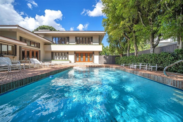 view of pool featuring french doors, a patio, a fenced in pool, and fence