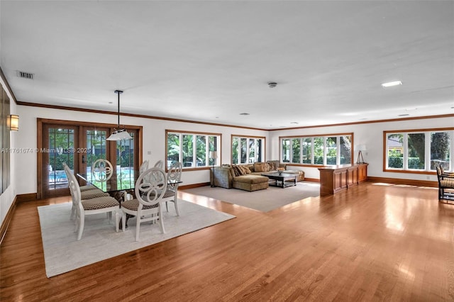 unfurnished dining area with wood finished floors, visible vents, baseboards, french doors, and crown molding