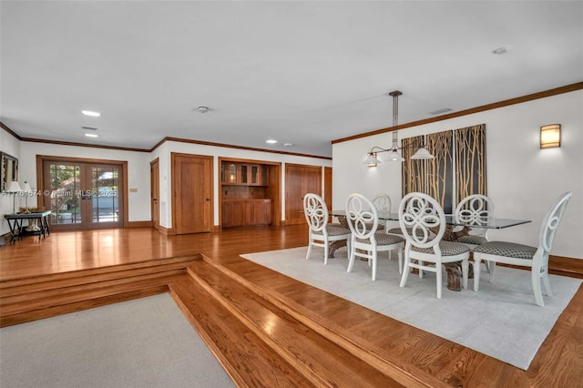 dining space featuring french doors, visible vents, wood finished floors, and ornamental molding