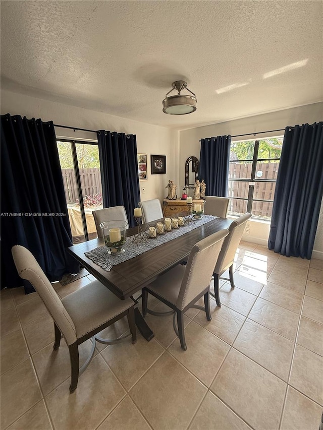 dining area with light tile patterned floors and a textured ceiling