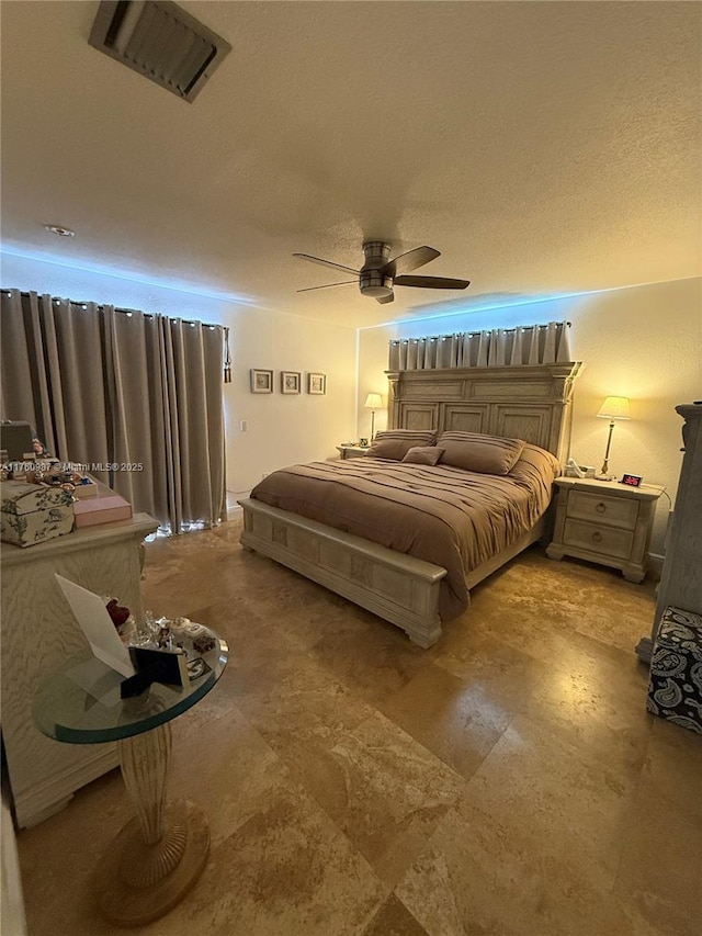 bedroom with visible vents, a textured ceiling, and a ceiling fan