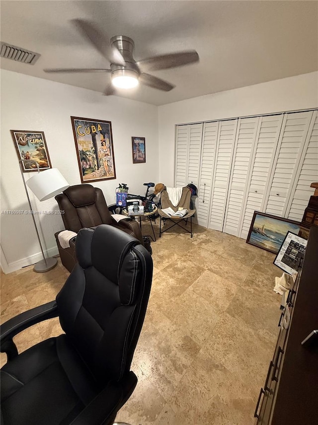 interior space featuring visible vents, baseboards, and ceiling fan