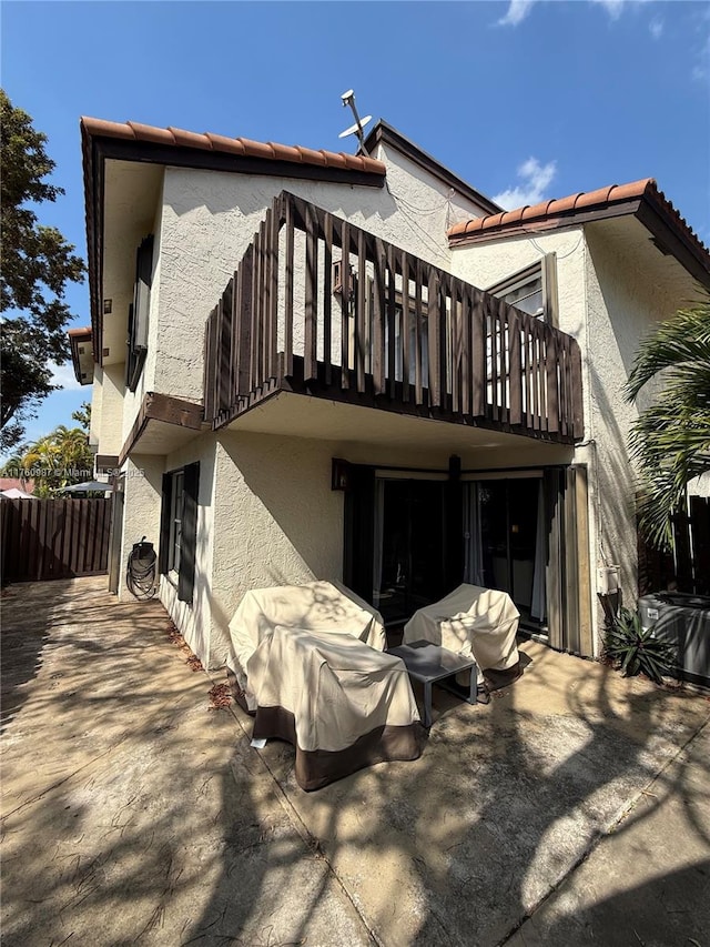 rear view of house with stucco siding and a patio area