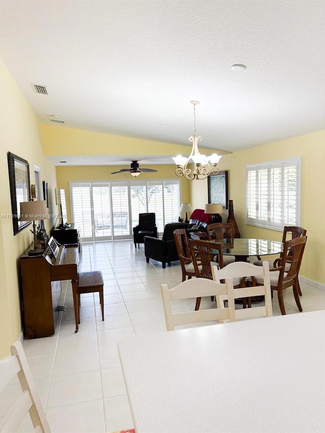 dining area with light tile patterned flooring, visible vents, a healthy amount of sunlight, and lofted ceiling