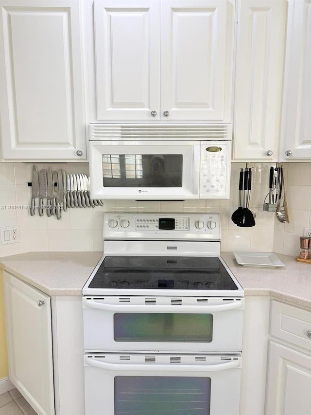 kitchen featuring tasteful backsplash, white appliances, white cabinetry, and light countertops