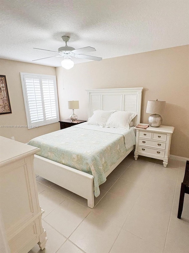 bedroom featuring tile patterned floors, a textured ceiling, and a ceiling fan