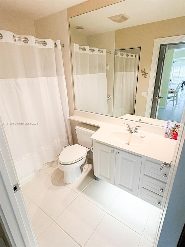 full bath with tile patterned floors, curtained shower, toilet, and vanity