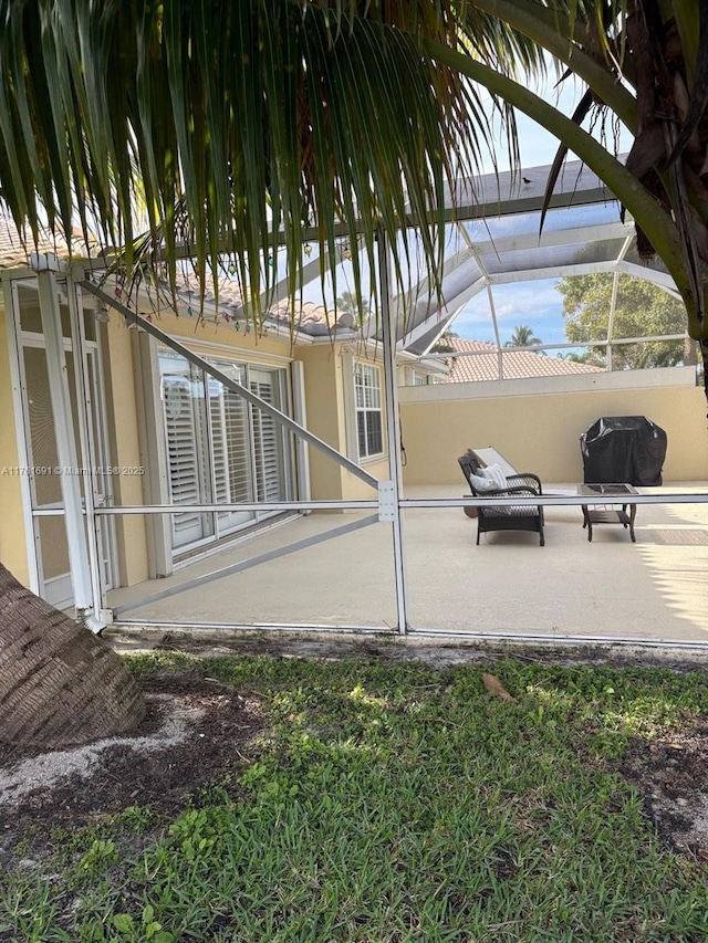 view of patio with glass enclosure