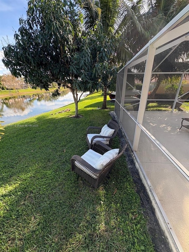 view of yard with a water view and a lanai