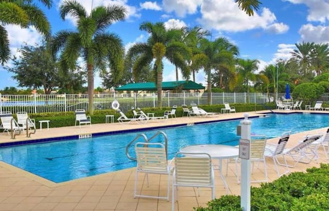 pool with a patio and fence