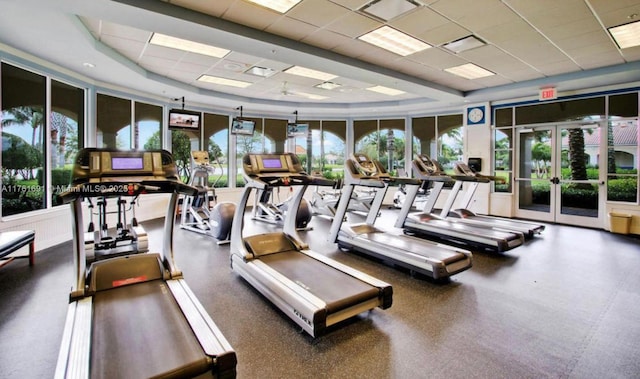 exercise room featuring a drop ceiling, a raised ceiling, visible vents, and french doors