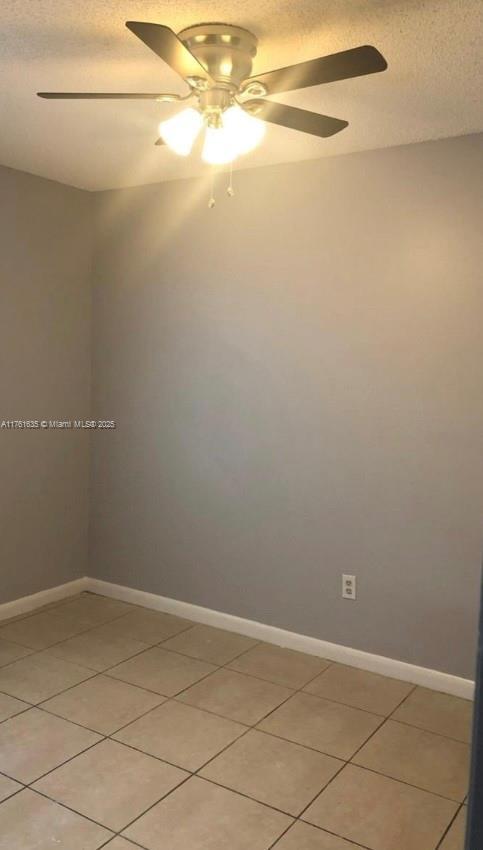 unfurnished room featuring a ceiling fan, baseboards, and a textured ceiling