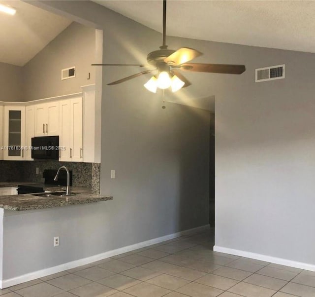 kitchen with a sink, visible vents, and lofted ceiling