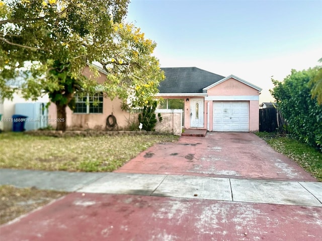 ranch-style house with concrete driveway, an attached garage, fence, and stucco siding