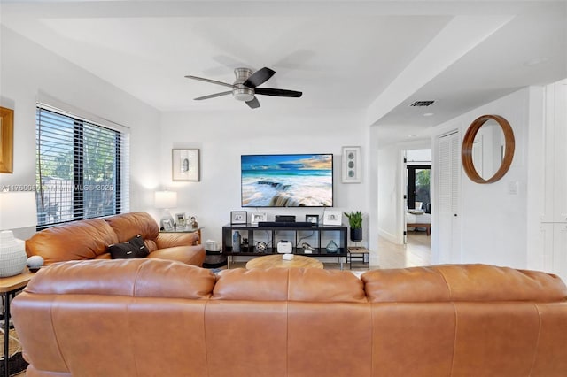 living area featuring visible vents and ceiling fan