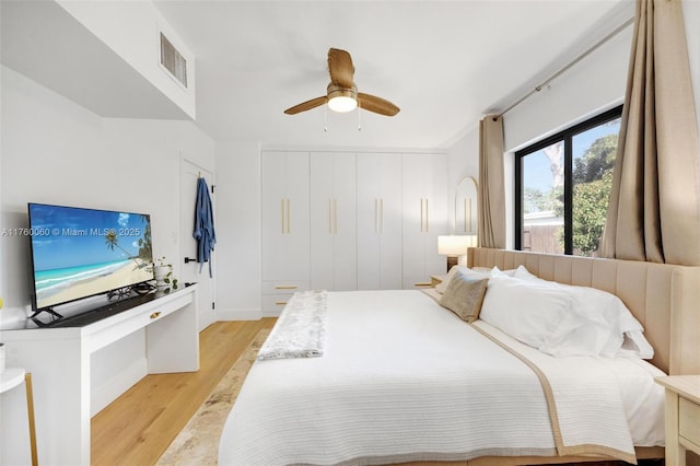 bedroom featuring a ceiling fan, light wood-style floors, and visible vents