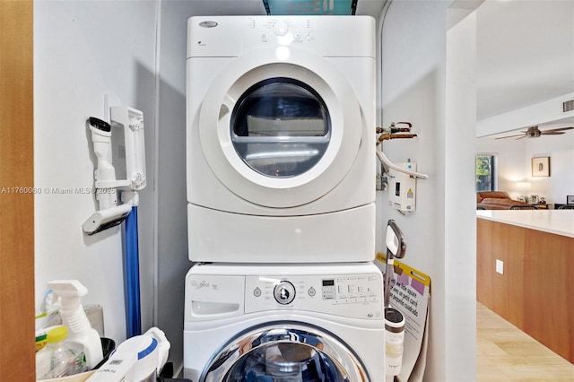 clothes washing area with a ceiling fan, laundry area, and stacked washing maching and dryer