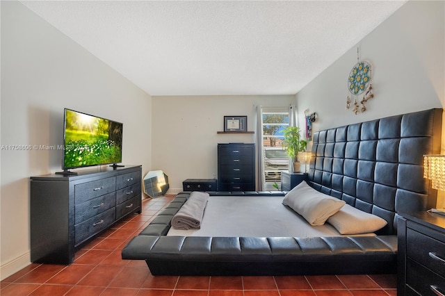 bedroom featuring baseboards and dark tile patterned floors