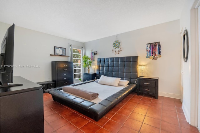 tiled bedroom with baseboards and a textured ceiling