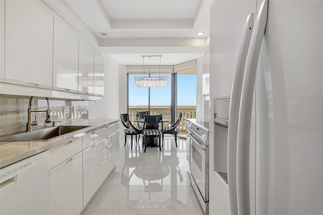 kitchen with white appliances, white cabinetry, modern cabinets, and a sink