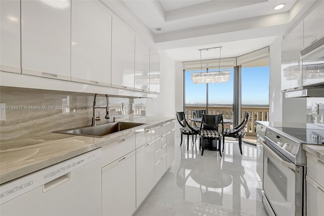 kitchen with decorative backsplash, white appliances, modern cabinets, and a sink