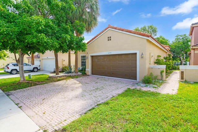 view of front of house with a tile roof, decorative driveway, and stucco siding